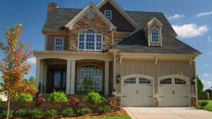 Traditional two-story brick and stone home with arched windows and beautifully manicured bushes.