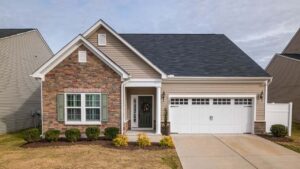 Cozy grey single-story house with a front-entry garage and a neat concrete driveway.