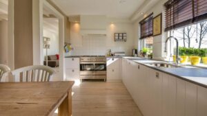Spacious luxury kitchen with a large white center island, modern pendant lights, and stainless steel appliances.