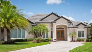 Spanish-style single-family home with a red barrel-tile roof, stucco walls, and arched windows.