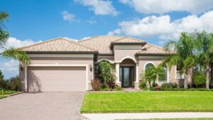 Single-story beige ranch-style suburban home with a manicured green lawn.